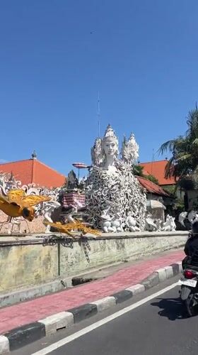 Morning traffic flows through tree-lined streets in Bali