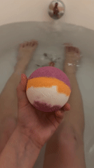 Person prepares striped bath bomb for evening bath in Eilat
