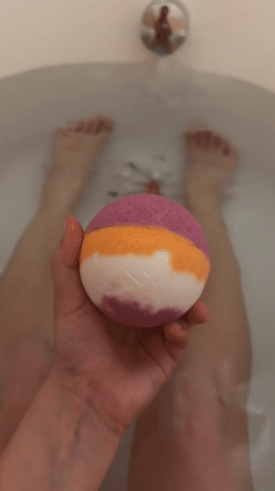 Person prepares striped bath bomb for evening bath in Eilat