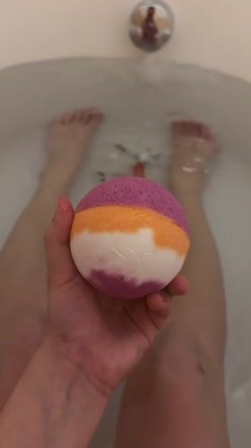 Person prepares striped bath bomb for evening bath in Eilat