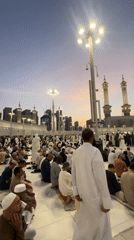 Worshippers in white gather on tiled ground in Makkah