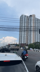 Woman with child rides scooter at Chiang Mai intersection