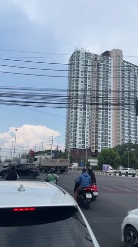 Woman with child rides scooter at Chiang Mai intersection