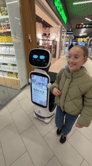 Girl encounters service robot at Latvia shopping mall