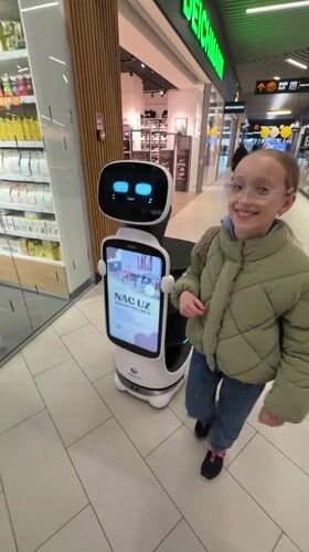 Girl encounters service robot at Latvia shopping mall
