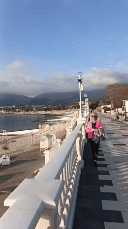 Woman walks beachside walkway at Novorossiysk resort