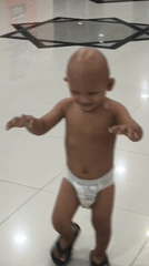 Dancing toddler and an ornate Indonesian plaque in Banda Aceh