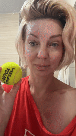 Tennis ball used for neck and chest self-massage in Sochi bathroom