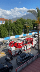 Tow truck operates on Fethiye street amid parked vehicles