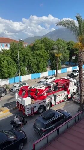 Tow truck operates on Fethiye street amid parked vehicles