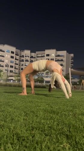 Woman performs yoga wheel pose on Dubai lawn