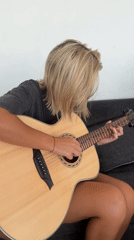 Woman plays acoustic guitar, takes selfie in North Kuta