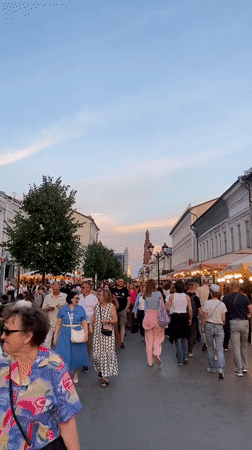 Evening crowd strolls Kazan pedestrian street at sunset