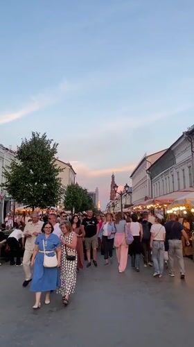 Evening crowd strolls Kazan pedestrian street at sunset