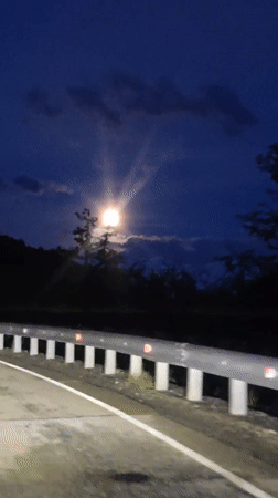 Full moon illuminates nighttime road scene in Estosadok, Russia