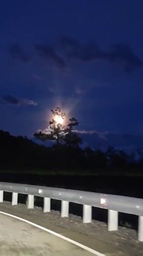 Full moon illuminates nighttime road scene in Estosadok, Russia