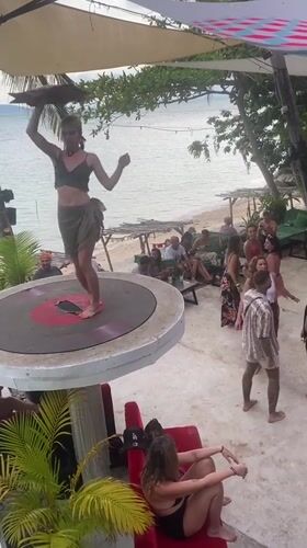 Woman dances on record platform at Thailand beach party