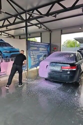 Man washes black sedan at Hadiach car wash