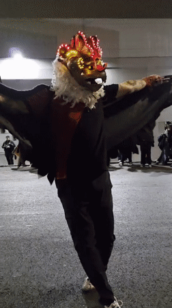 Costumed street performers dance with musicians in Iquique nighttime event