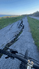 Cyclist navigates damaged asphalt path in Burgas, Bulgaria