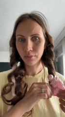 Woman styles hair with curling rods in Fethiye