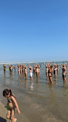 Group water aerobics and beach crowds on a sunny Gatteo morning