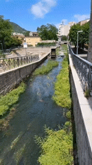 Stone canal and shaded walkway along Bojano's waterway