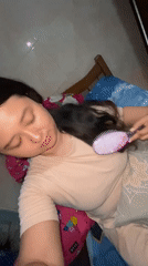 Woman brushes hair in bedroom, Gelam Indonesia