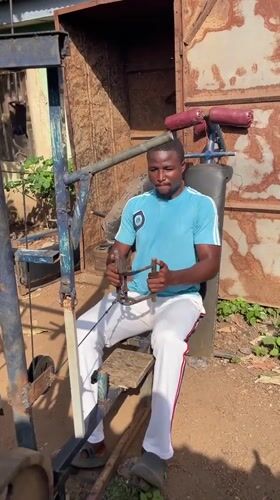 Man uses homemade gym equipment outdoors in Akwanga