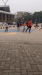 Kids playing on a multi-use outdoor court in Melayu, Indonesia