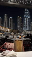 Outdoor restaurant dining captured against Dubai's illuminated skyline