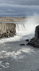 Family visits dramatic Icelandic waterfall, captures scenic cliff-edge portraits
