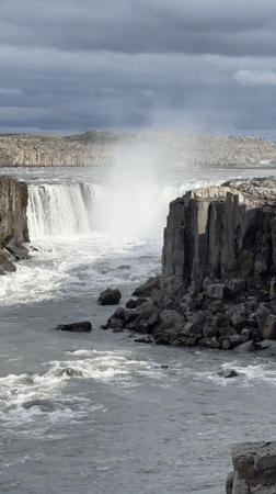 Family visits dramatic Icelandic waterfall, captures scenic cliff-edge portraits