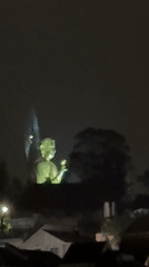 Green-lit Buddha statue observed at night in Đà Lạt