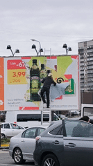 Billboard maintenance worker updates advertisements in Riga