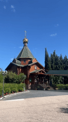 Roses bloom near wooden Orthodox church in Sevastopol