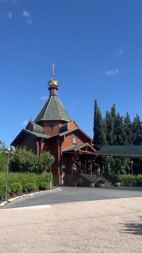 Roses bloom near wooden Orthodox church in Sevastopol