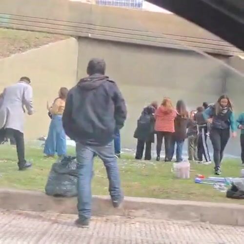 People gather, collect items near concrete structure in Buenos Aires