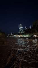 Nighttime riverbank view captures lit Tbilisi skyline