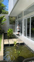 Man walks as dog drinks from pond at residence