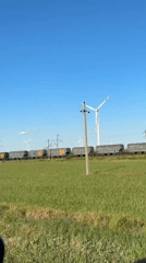 Cargo train passes through wind farm near Zimovniki, Russia