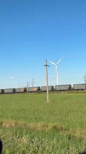 Cargo train passes through wind farm near Zimovniki, Russia