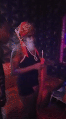 Woman with hookah captured in colorful lighting in Yelwa