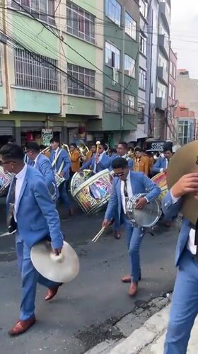 Traditional parade with marching band proceeds through La Paz streets