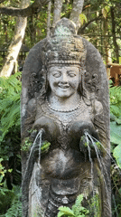 Temple fountain and macaque at a rocky Ubud water feature