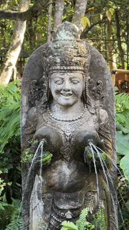 Temple fountain and macaque at a rocky Ubud water feature