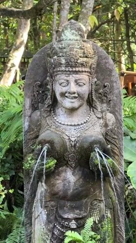 Temple fountain and macaque at a rocky Ubud water feature