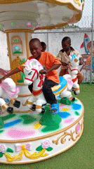 Children play on carousel and swings at outdoor playground