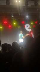 Soccer-jersey clad performer holds letter balloon on Tel Aviv stage
