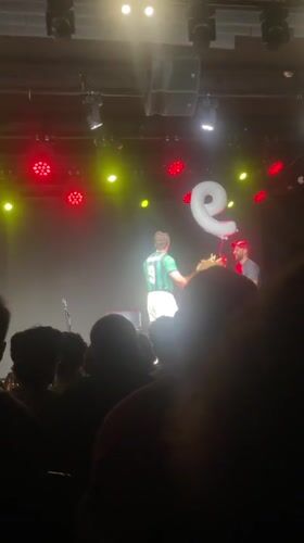 Soccer-jersey clad performer holds letter balloon on Tel Aviv stage